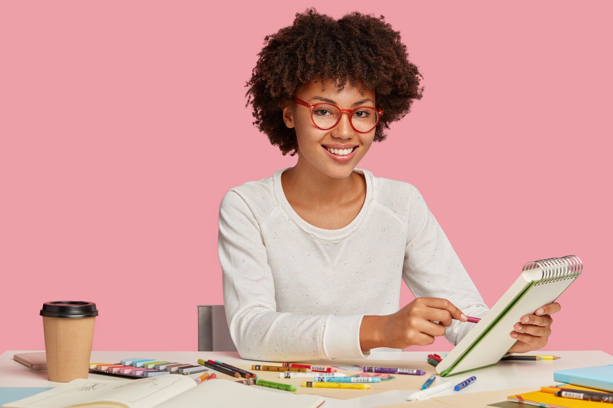 horizontal-shot-of-cheerful-afro-african-painter-wears-red-rim-spectacles-makes-sketches-in-spiral.jpg
