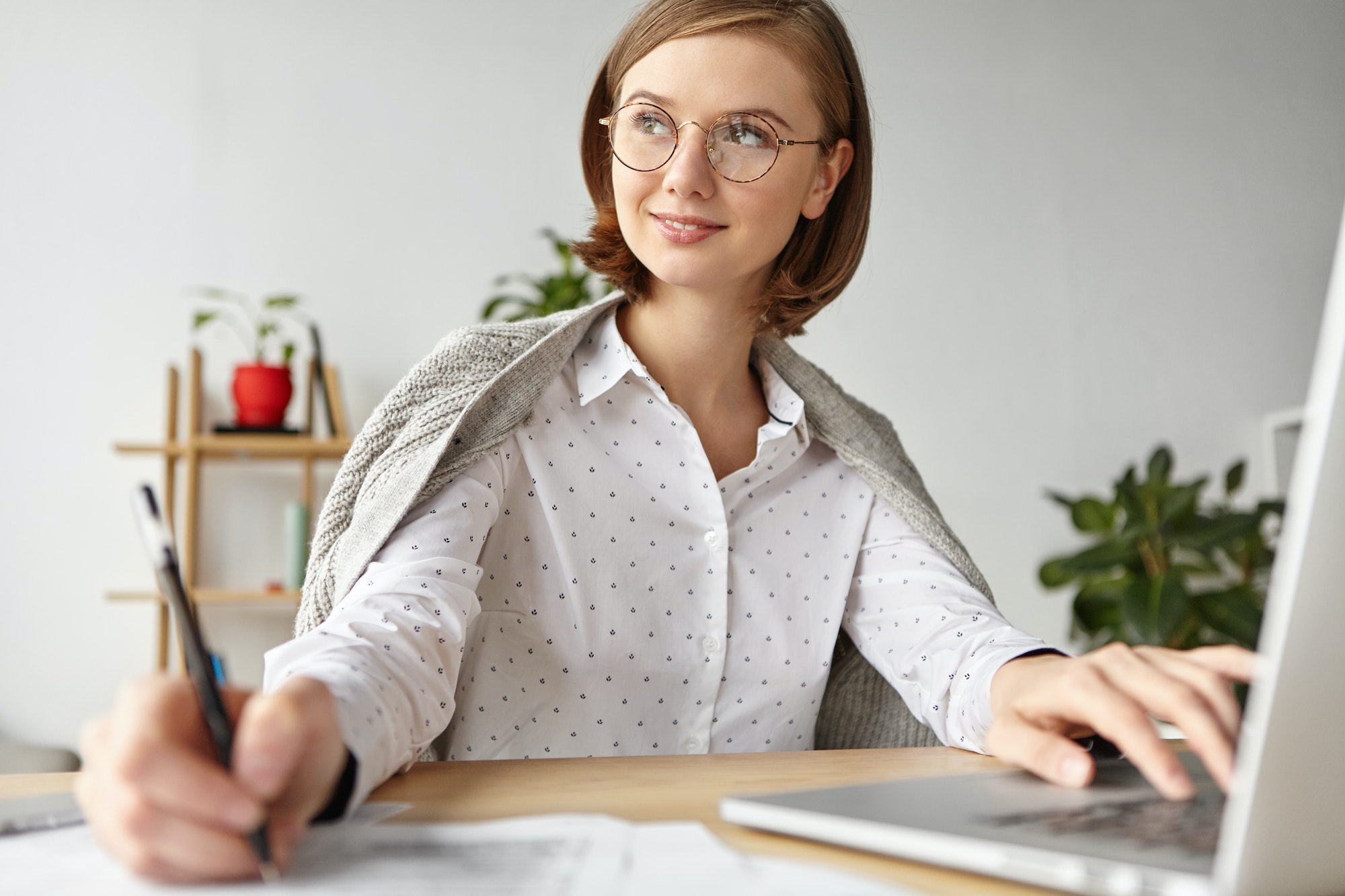 thoughtful-businesswoman-with-bobbed-hairstyle-dressed-in-white-blouse-writes-with-pen-in-diary-an.jpg